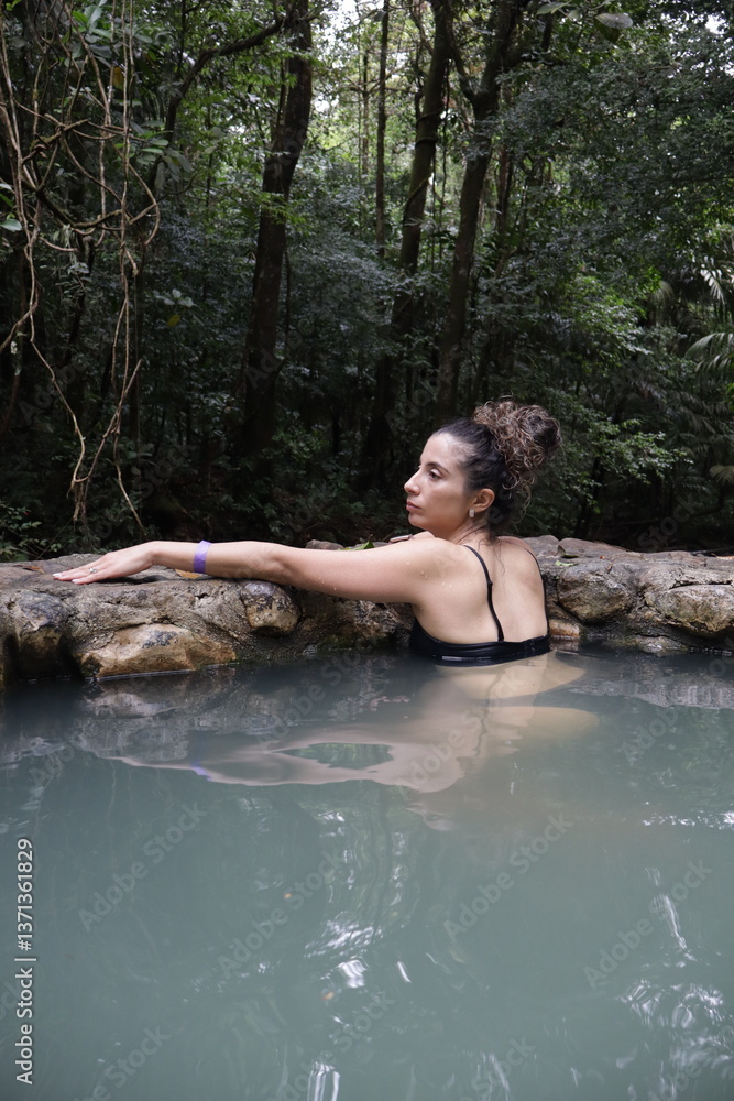 Fototapeta premium girl enjoying thermal wather in tropical forest