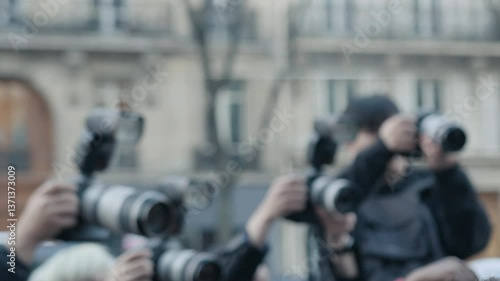 Paparazzi taking photos of celebrity arriving in car
