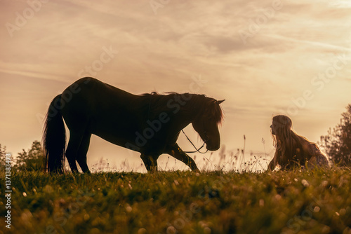 Obraz na płótnie A female equestrian and her horse interacting together. Romantic freedom sunset scene w salonie