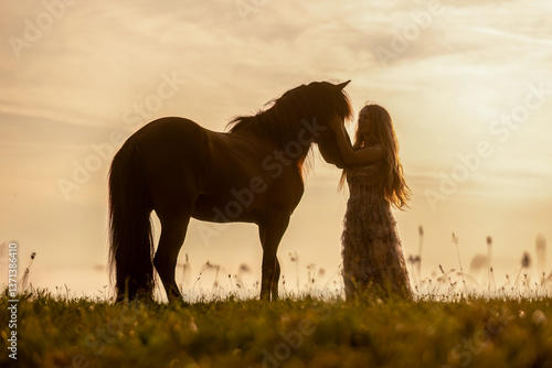 Obraz na płótnie A female equestrian and her horse interacting together. Romantic freedom sunset scene w salonie