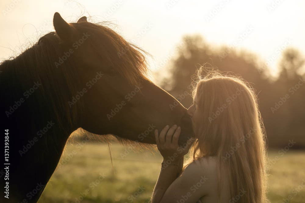 A female equestrian and her horse interacting together. Romantic freedom sunset scene