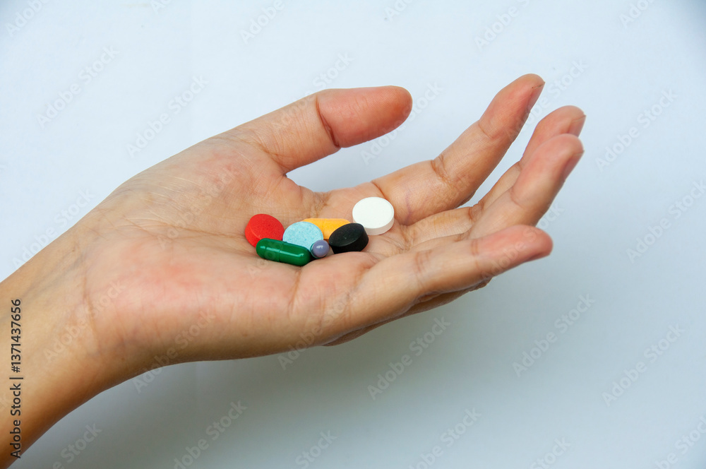 Hand showing variety of colorful pills and capsules with customizable space for text. Medical and health matters concept. Hand showing variety of colorful pills and capsules with customizable space for text. Medical and health matters concept.