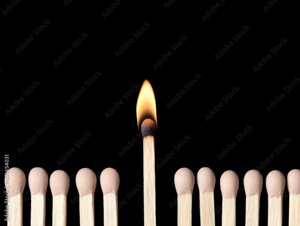 single small flame atop matchstick stands alone among row of unlit matchsticks, creating striking contrast against black background. image evokes sense of individuality and resilience single small flame atop matchstick stands alone among row of unlit matchsticks, creating striking contrast against black background. image evokes sense of individuality and resilience