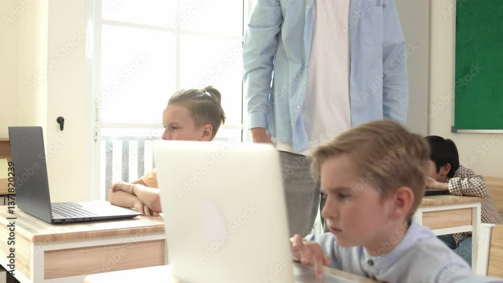 Caucasian teacher helping american student coding engineering prompt while diverse student using software generated AI. Smart attractive children sitting and programing system. Education. Pedagogy. Caucasian teacher helping american student coding engineering prompt while diverse student using software generated AI. Smart attractive children sitting and programing system. Education. Pedagogy.