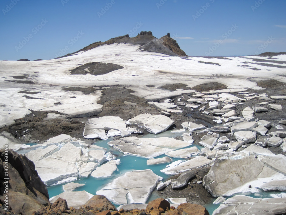 Ice covered pool of water on the hills of Mt Ruapehu summit track. North Island. New Zealand.