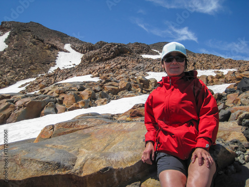 Obraz na płótnie Woman taking a rest among ice covered rocks. Mt Ruapehu summit track. North Island. New Zealand. w salonie
