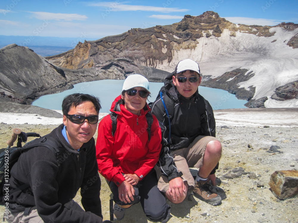 Hikers posing for photos at Mt Ruapehu Crater Lake. North Island. New Zealand.