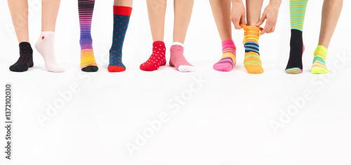 Down syndrome awareness, lost sock memorial day concept. Women legs with various colorful socks on feet in white background with copy space