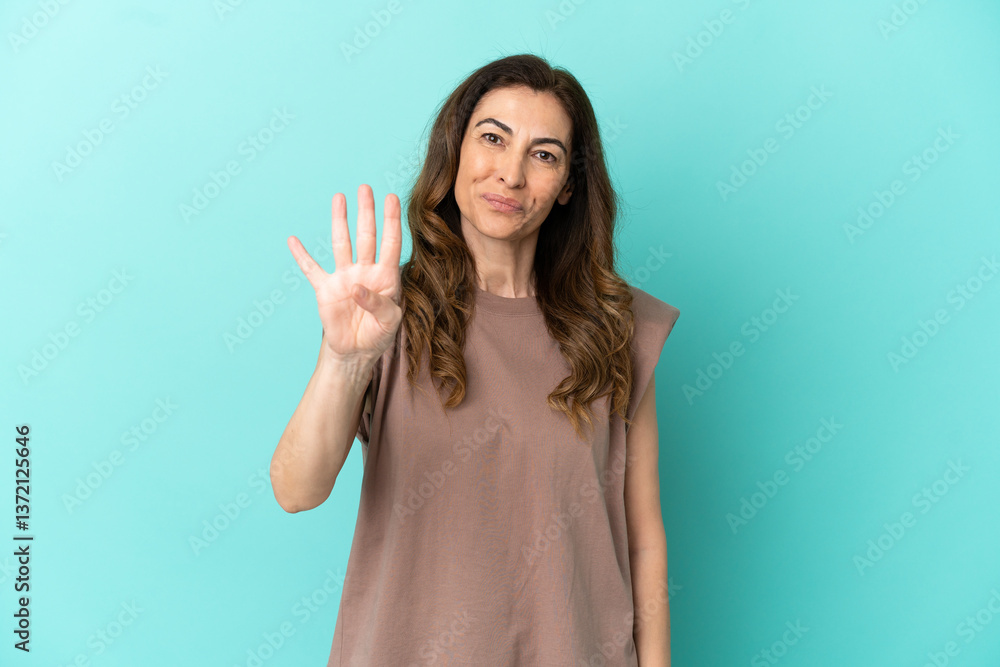 Fototapeta premium Middle aged caucasian woman isolated on blue background happy and counting four with fingers