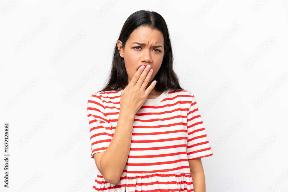 Young Colombian woman isolated on white background yawning and covering wide open mouth with hand Young Colombian woman isolated on white background yawning and covering wide open mouth with hand