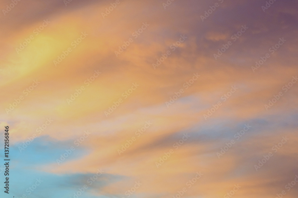 Obraz premium Sky with soft and fluffy pastel orange pink and blue colored clouds. Sunset background. Nature. sunrise.