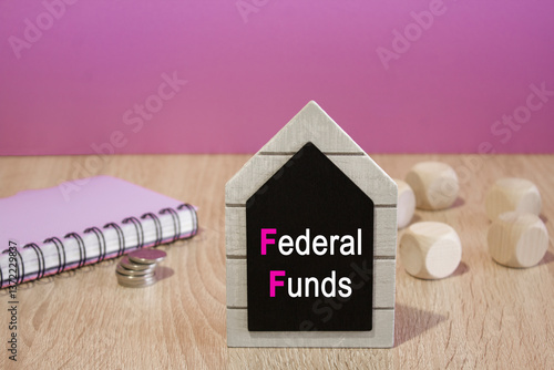 Obraz na płótnie Text FEDERAL FUNDS on a black board. Beautiful purple background. Notebook and silver coins on the table. Business concept. w salonie
