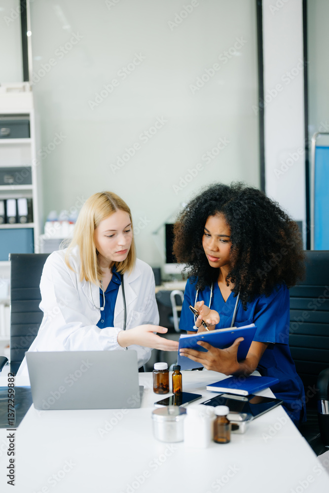 Fototapeta premium Doctors and nurses using laptops and clipboards, showcasing teamwork, modern healthcare.