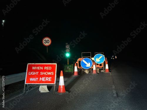 Temporary traffic lights with a when red light shows wait here sign on a residential street.