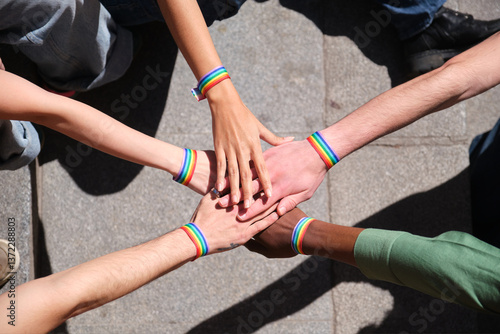 Obraz na płótnie Group of activists joining hands wearing rainbow wristbands at a LGBT pride parade celebrating diversity and inclusion w salonie