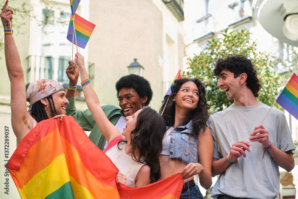 Group of happy multi ethnic friends having fun together waving rainbow flags at a LGBT pride parade
