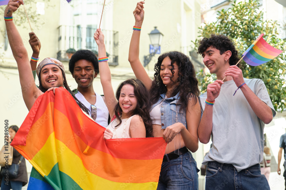 Young people celebrating LGBT pride holding rainbow flag and waving rainbow flags