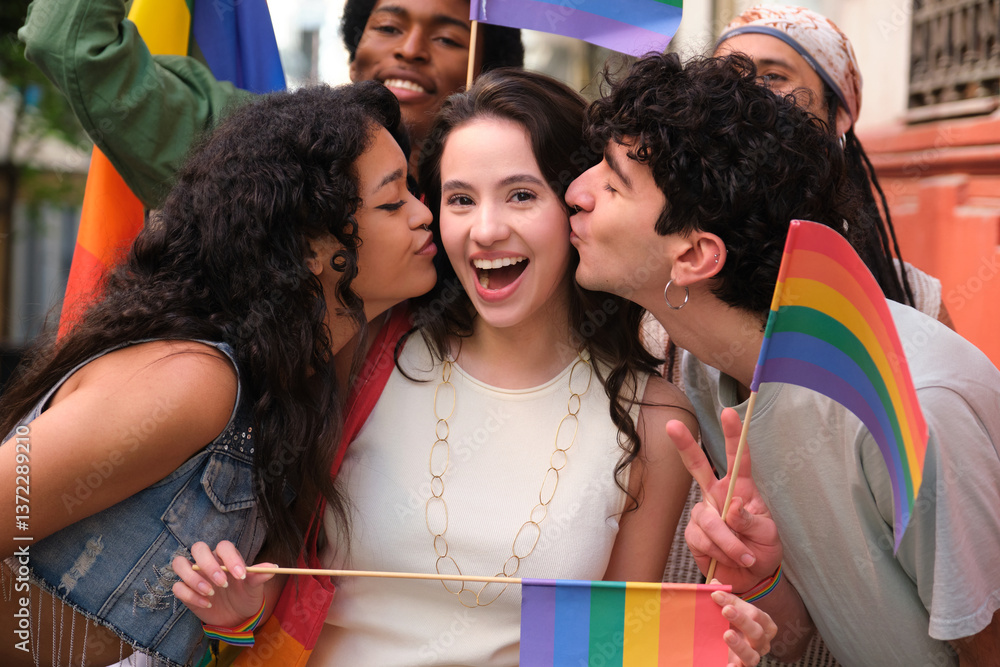 Group of friends celebrating at LGBT pride parade, kissing girl on the cheek and holding rainbow flags
