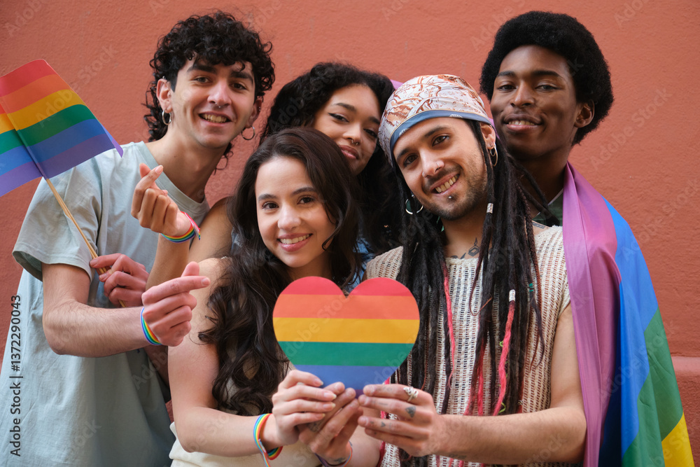 Group of friends showing their support for LGBT community by holding rainbow heart and flags