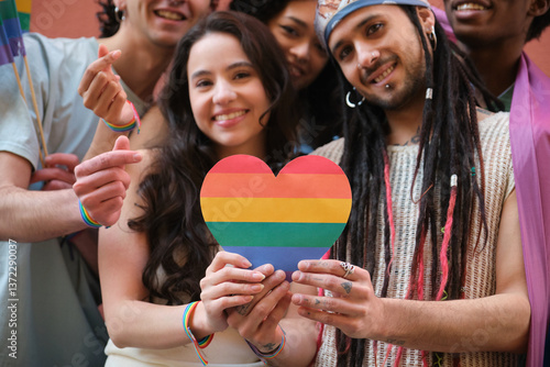 Obraz na płótnie Group of smiling multi ethnic young people holding rainbow heart celebrating LGBT pride w salonie