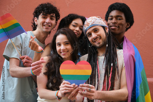 Obraz na płótnie Group of friends showing their support for LGBT community by holding rainbow heart and flags w salonie