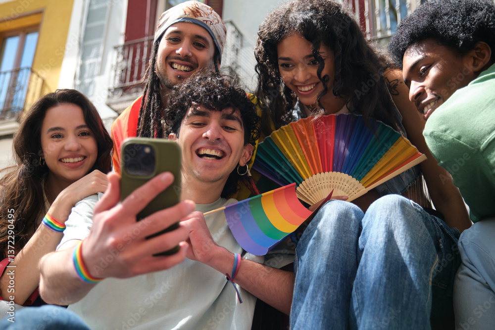 Happy multi ethnic friends taking selfie at LGBT pride parade, using smartphone and holding rainbow flag and fan