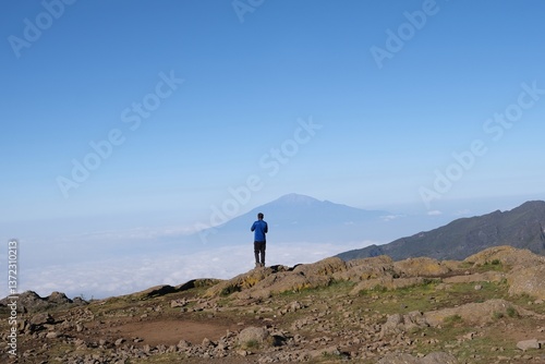 Obraz na płótnie Kilimanjaro, Tanzania: Single man standing on viewpoint on Shira Camp with Mount Meru in background. Machame Route, w salonie