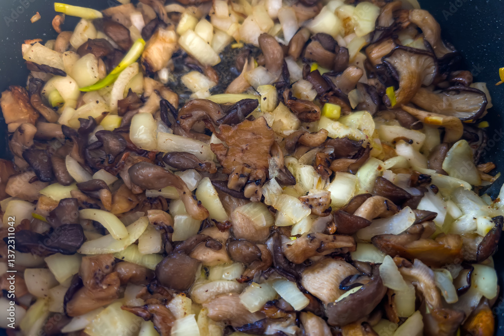 Oyster mushrooms during frying with chopped onion in frying pan Oyster mushrooms during frying with chopped onion in frying pan
