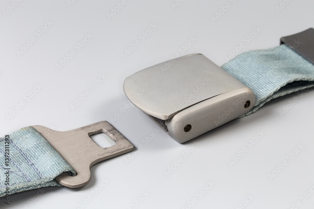 Fototapeta premium Unfastened buckle of airplane lap seat belt on gray background