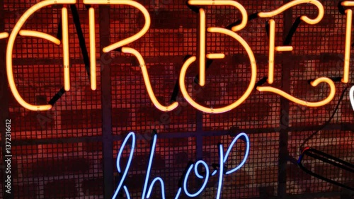 3d Animation. A dolly zoom shot of a vibrant, glowing Barber shop Neon Sign with moving shaving razor and  vintage, spinning  Barber shop pole grunge brick wall.