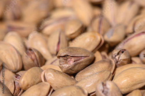 Close-up view of unshelled pistachio nuts scattered on the surface, showcasing their unique textures and colors