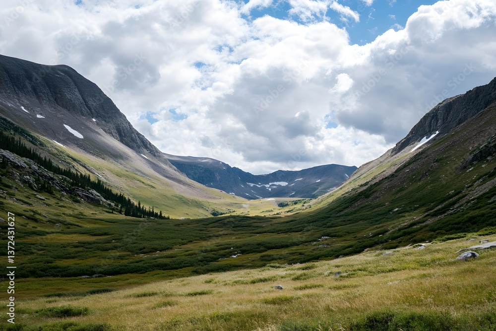 Mountain valley view with grassy fields and cloudy sky above Mountain valley view with grassy fields and cloudy sky above