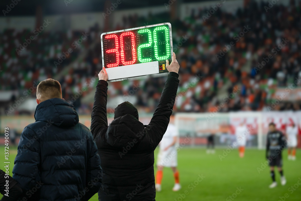 Team manager shows players substitution during football match.