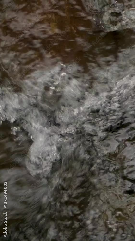 Fast-Flowing Water Splashing Over Rocks in StreamClose-up of turbulent stream water splashing against rocks with strong motion and natural texture.Water Splashing Over Rocks Fast-Flowing Water Splashing Over Rocks in StreamClose-up of turbulent stream water splashing against rocks with strong motion and natural texture.Water Splashing Over Rocks