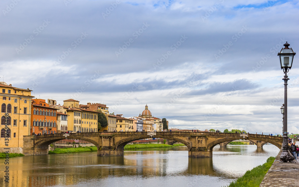 Street light, bridge and historic buildings at the river in Florence, Italy
