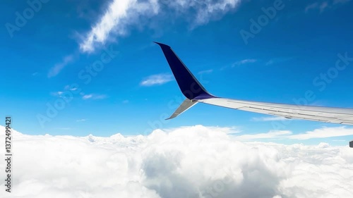 Serene Aerial View of Airplane Wing at High Altitude with Blue Sky and Fluffy White Clouds