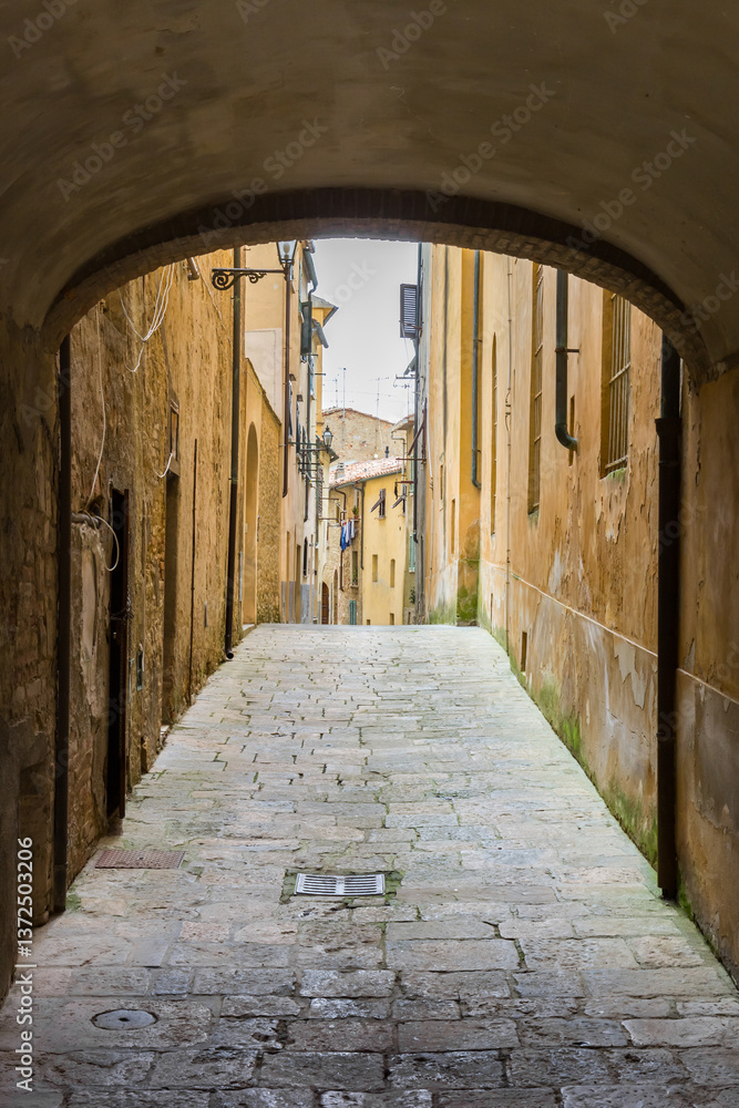 Arch over a narrow old street in historic city Volterra, Italy