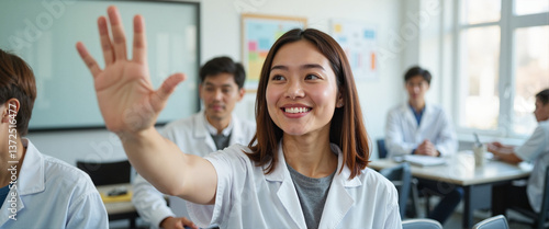 Smiling student raising hand in classroom setting