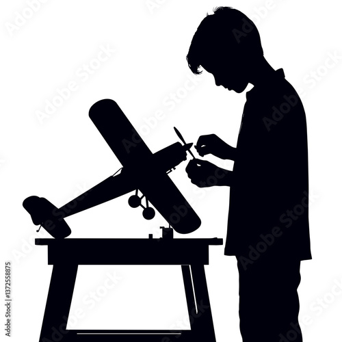 Child assembling model airplane silhouette at workbench  