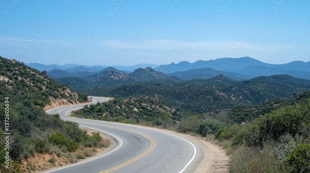 Winding mountain road, scenic vista, clear blue sky, distant hazy mountains Winding mountain road, scenic vista, clear blue sky, distant hazy mountains