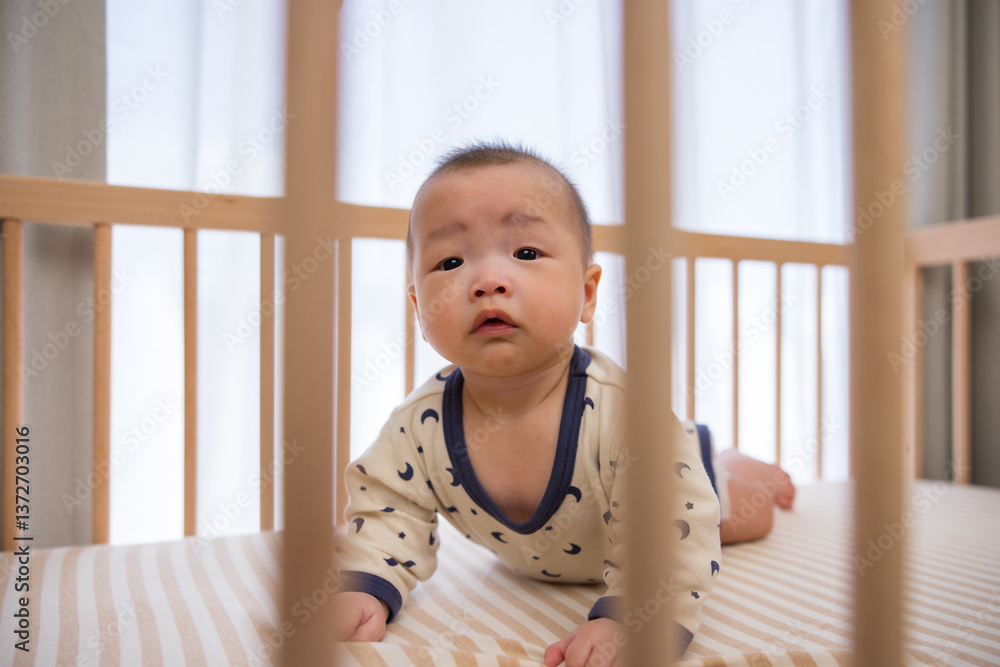 Cute baby crawling inside wooden crib safely
