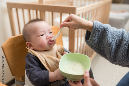 Smiling baby enjoying meal at home