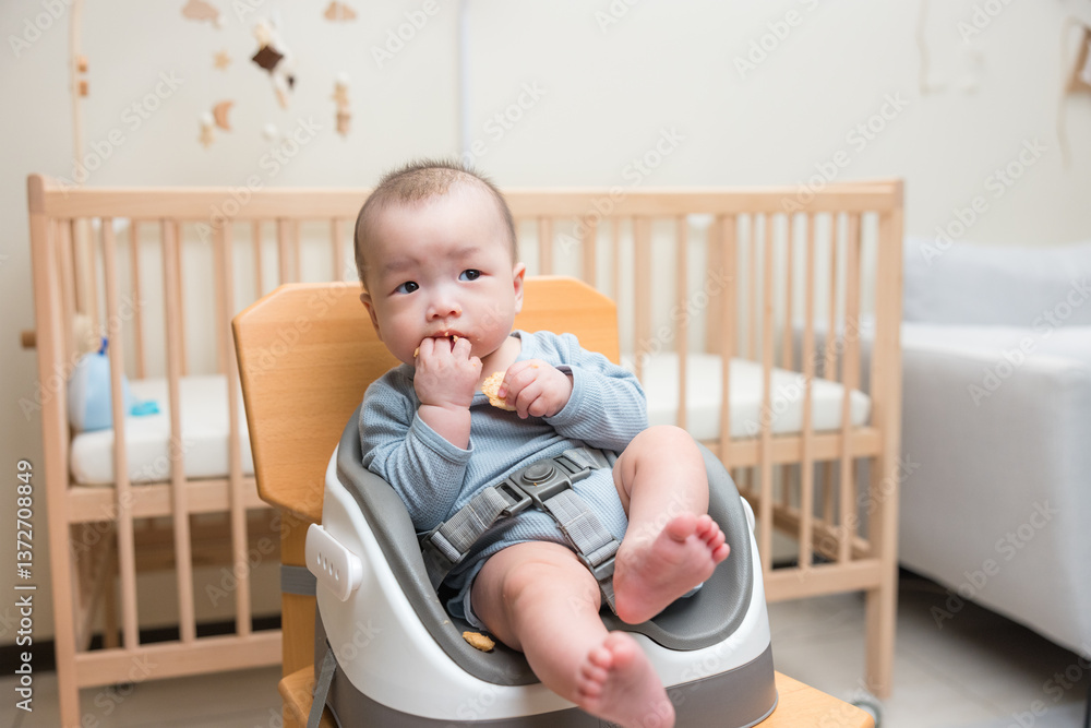 Cute baby boy eating food at home