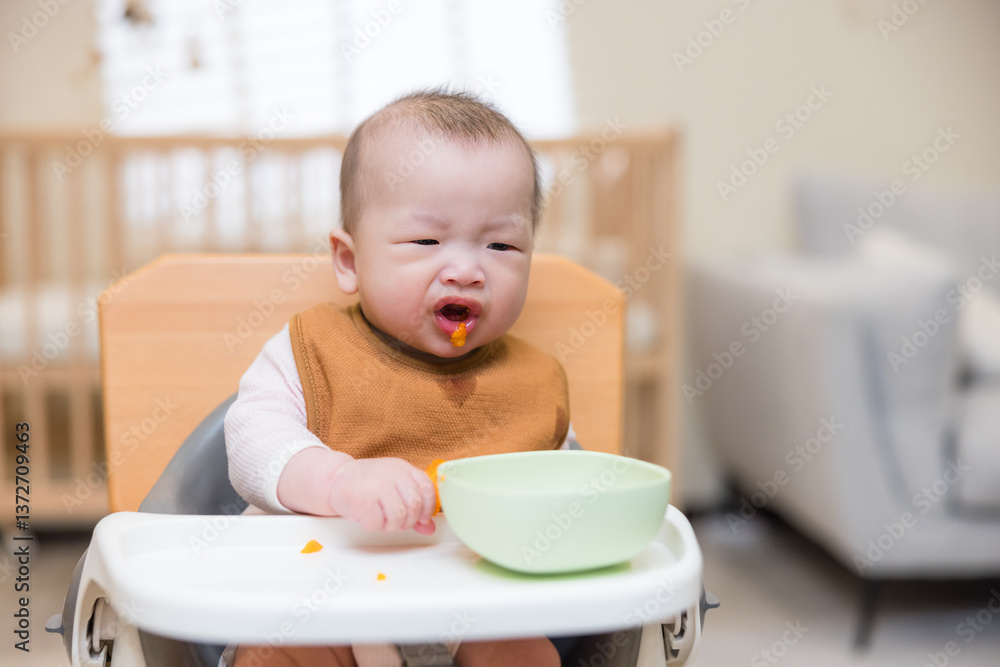 Baby sitting at table with feeding bowl