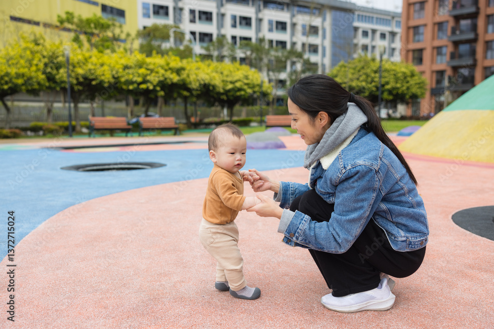 Loving mother guiding baby on playground