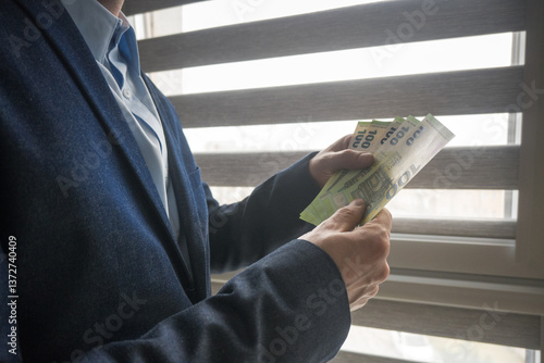 Obraz na płótnie Man in suit holding euro banknotes, business.
w salonie