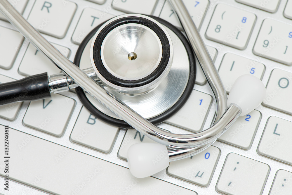 Ein medizinisches Stethoskop liegt auf einer Tastatur als Symbol für Bürokratie im Gesundheitswesen