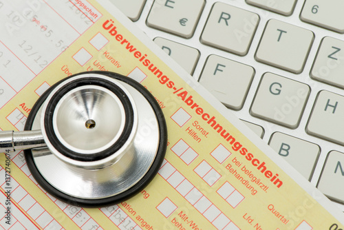 Obraz na płótnie Ein medizinisches Stethoskop und ein Formular für Überweisungs-/Abrechnungsschein liegen auf einer Tastatur als Symbol für Bürokratie im Gesundheitswesen w salonie