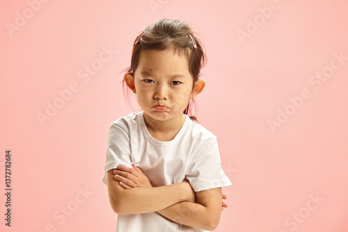 Εκτύπωση καμβά Offended Little Asian Girl Defiantly Crossed Arms in Front of Her Expressing Dissatisfaction and Resentment Standing Over Pink Isolated