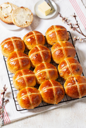 Obraz na płótnie Hot cross buns served with butter and blossoming apricot branches. w salonie